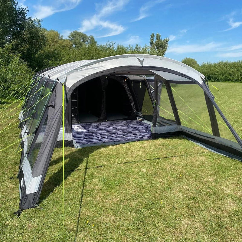 Photograph of open front Family 6 Steel Pole Tent - 6/8 Man Tent Khyam with carpet and front canopy attached on grassy campsite with blue sky sunny weather.